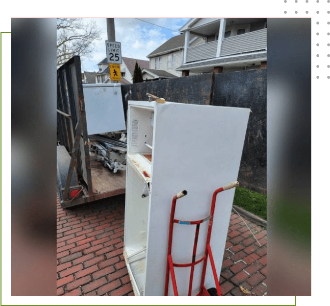 A white refrigerator sitting on top of a brick road.