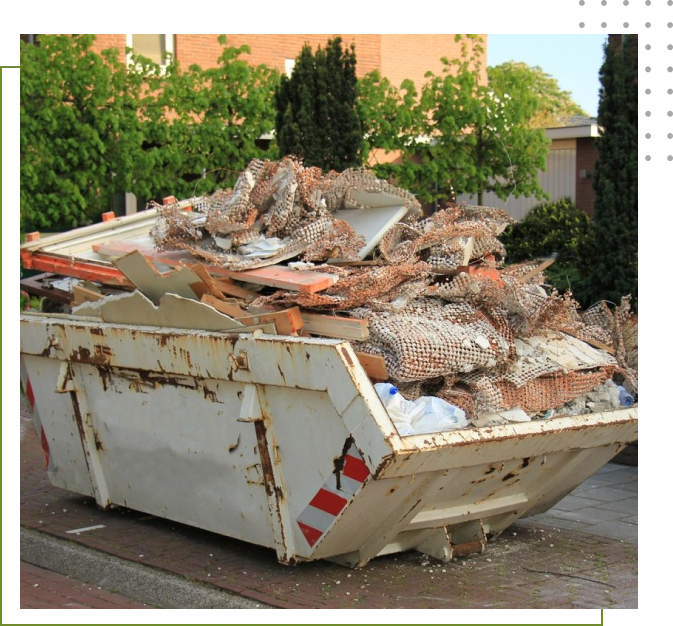 A dumpster full of rubble on the side of a street.