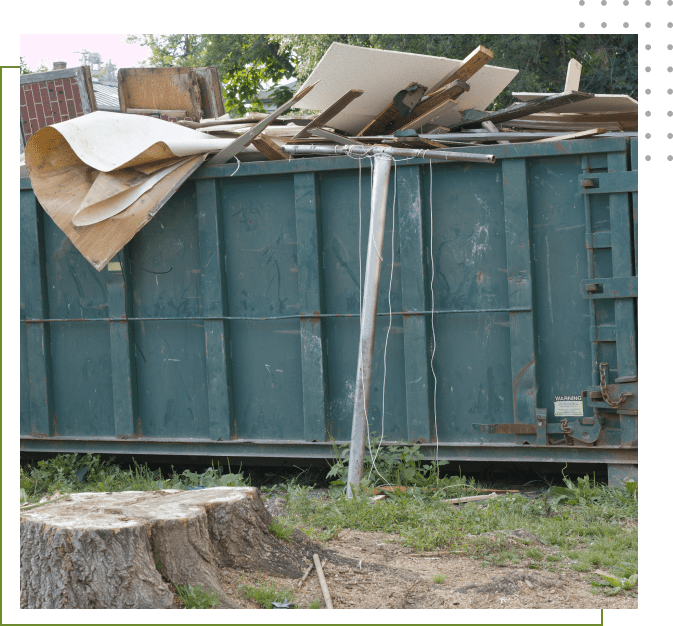 A dumpster with many items on top of it.