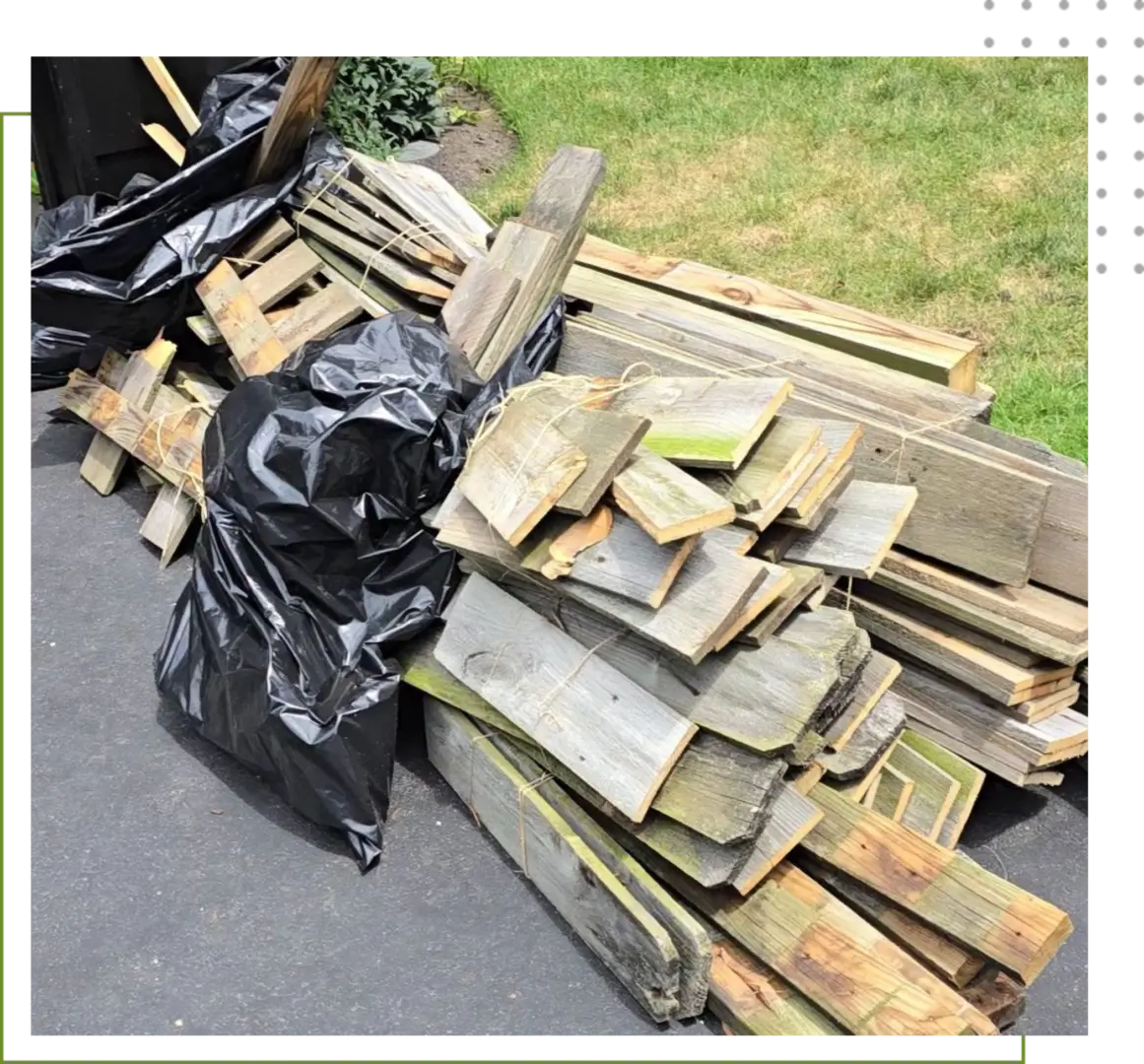 A pile of wood and trash bags on the ground.