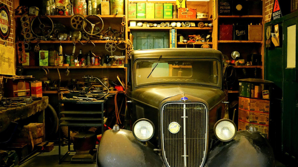 A classic car and junk inside a garage