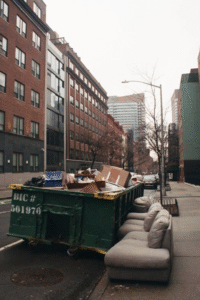 Piles of discarded furniture and trash outside an apartment complex
