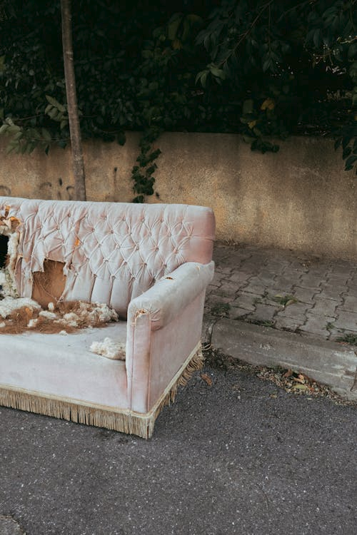 An old upholstered couch placed curbside for removal