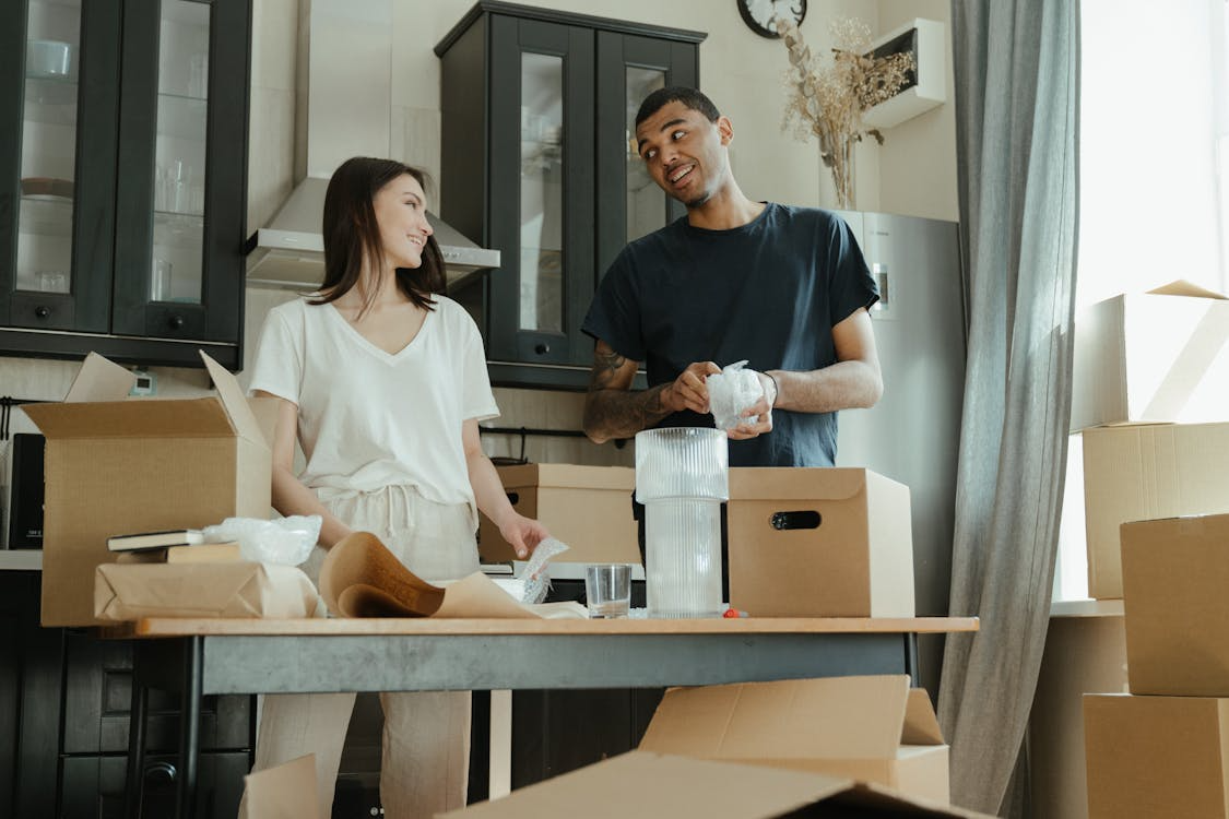 An image of a man and a woman packing boxes  