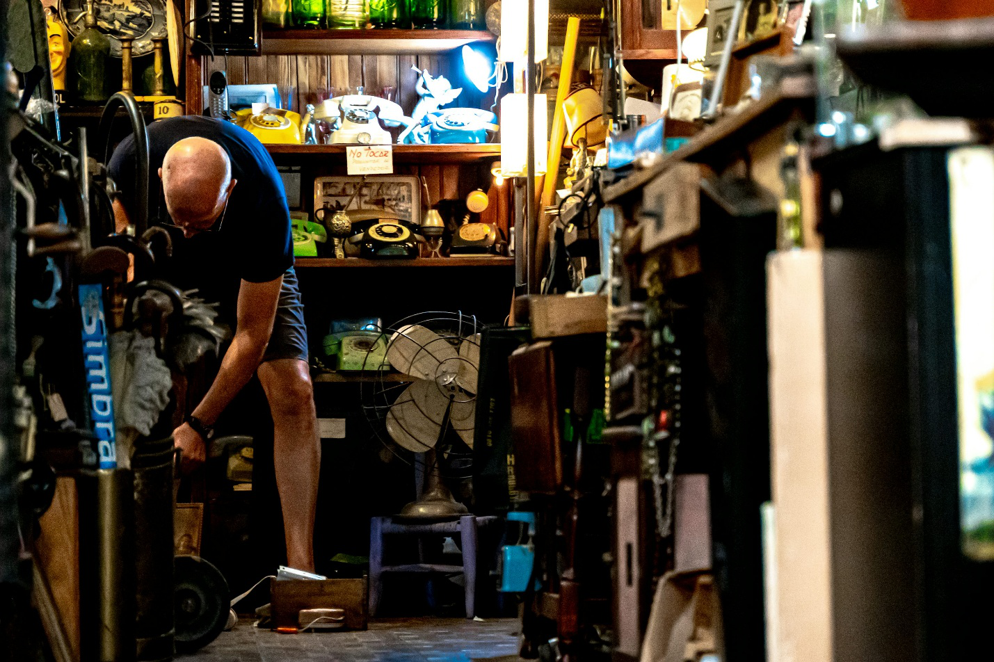 Man sorting through cluttered attic during cleanup.