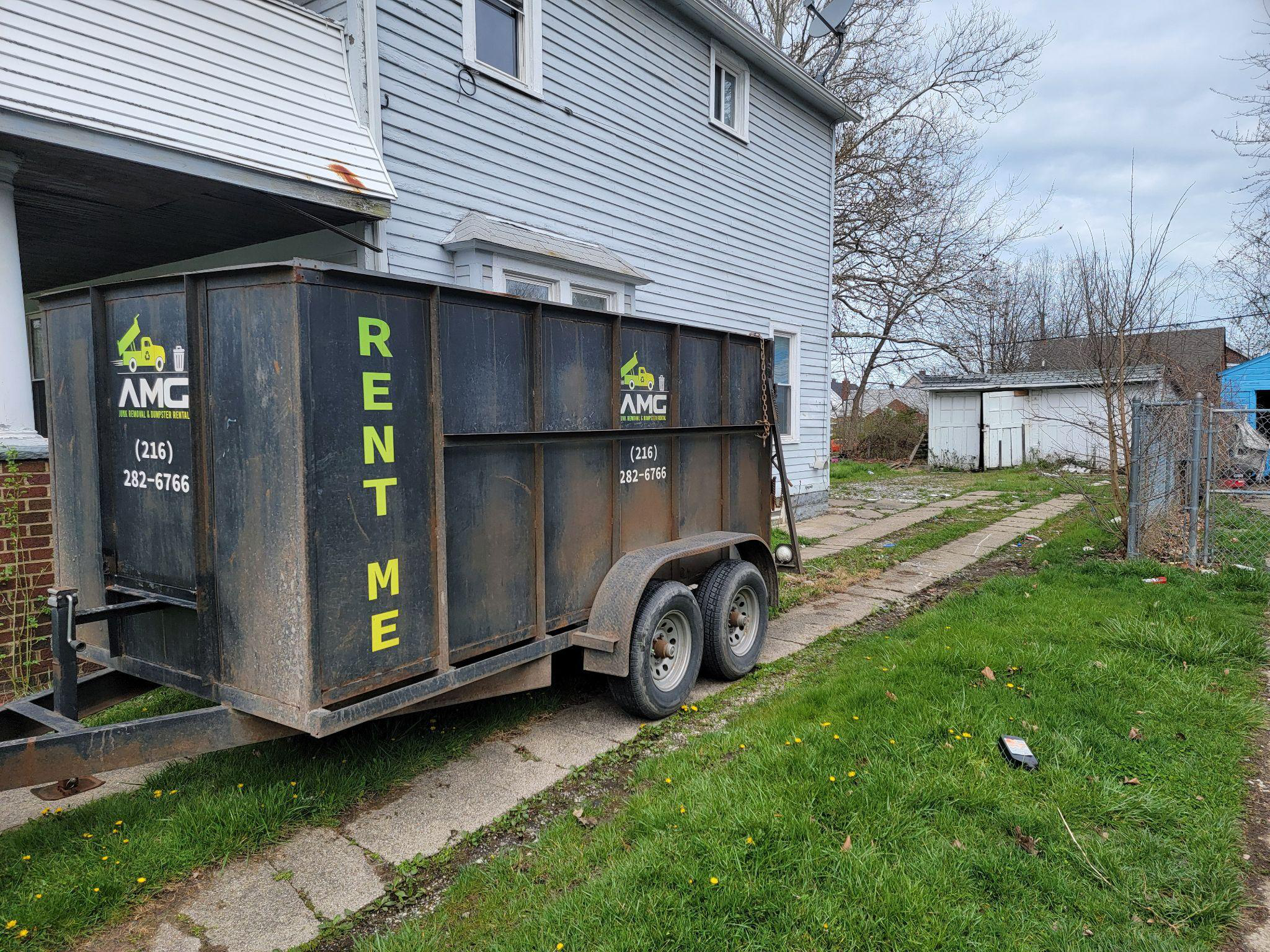 A dumpster in the backyard of a house.