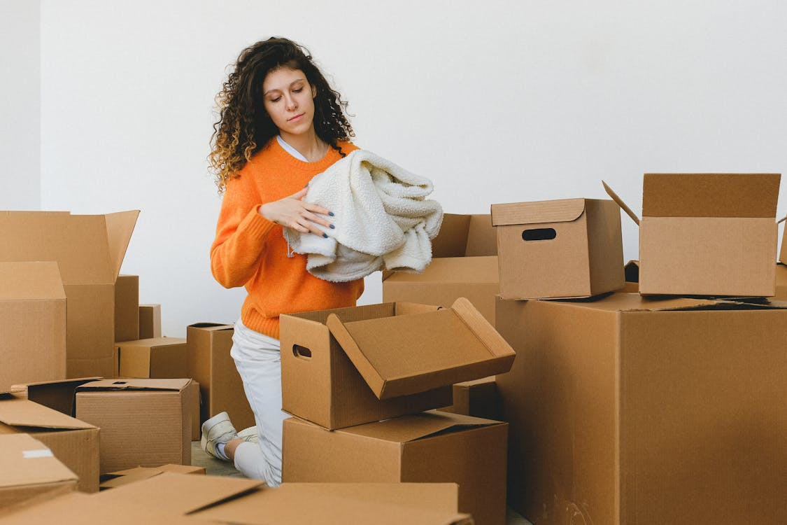 Woman organizing boxes during a house cleanup process.