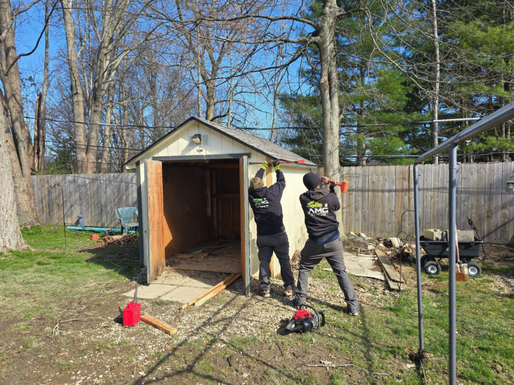 Two people taking down a shed.