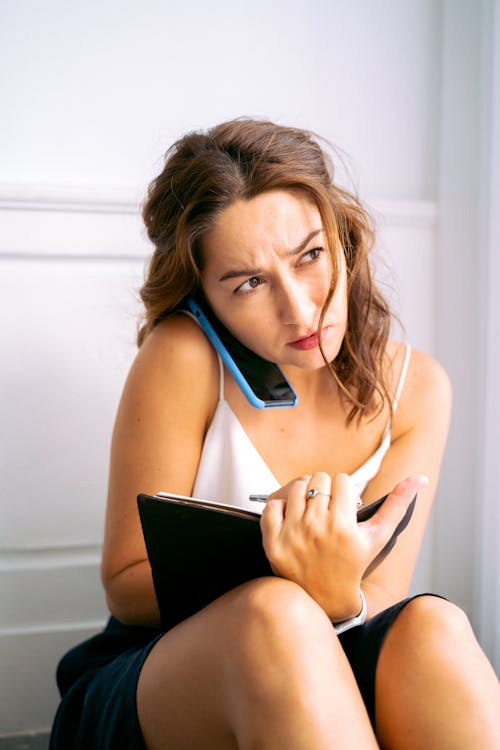 Woman stressed while calling junk removal services.