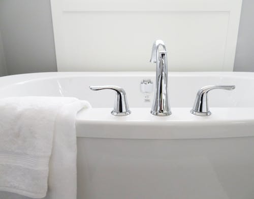 Modern bathtub with chrome fixtures and towel in a Solon home.