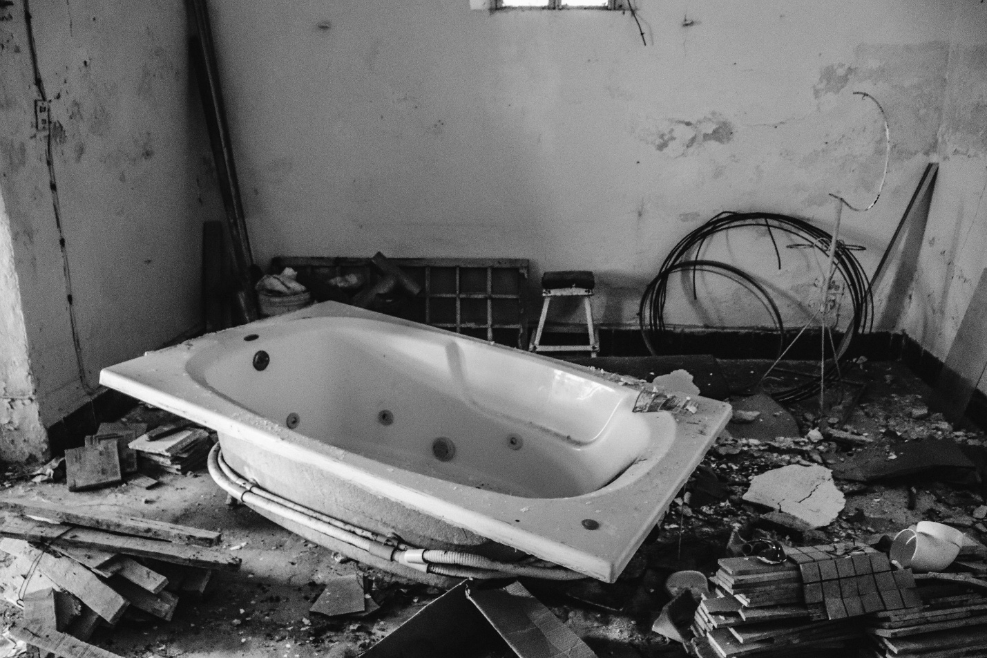 An abandoned hot tub surrounded by construction debris, showing common pitfalls of DIY hot tub removal in Beachwood.