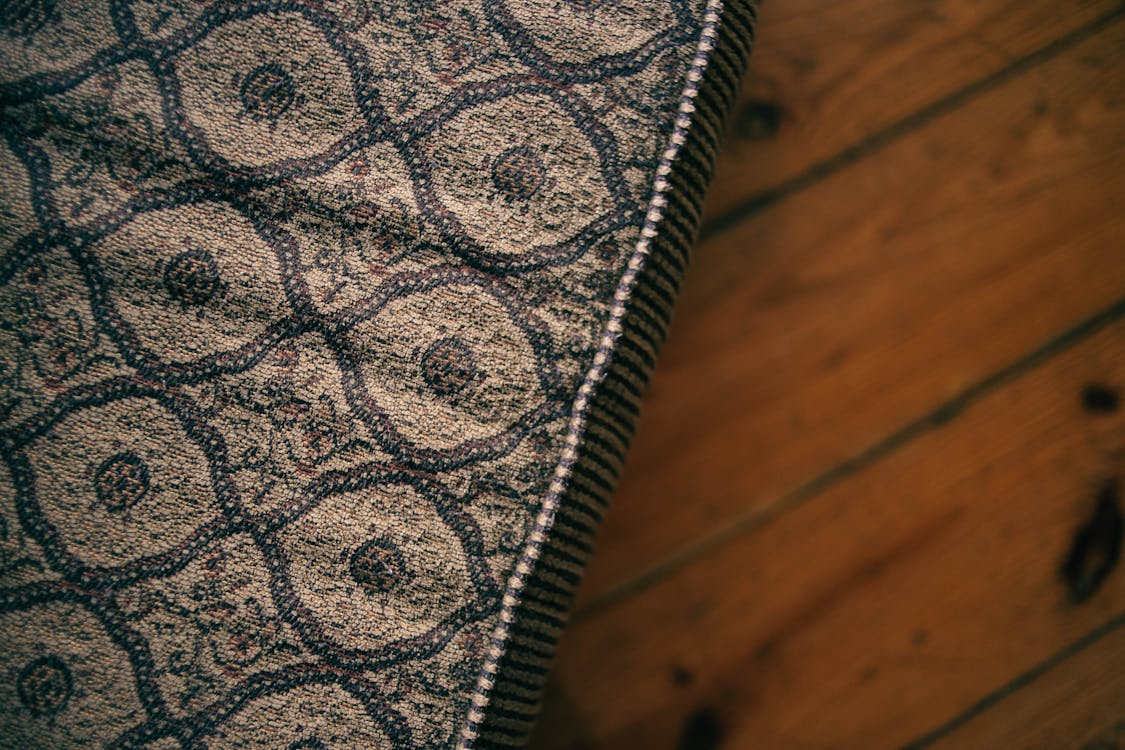 Close-up of an old mattress with worn fabric on a hardwood floor in Solon, Ohio.