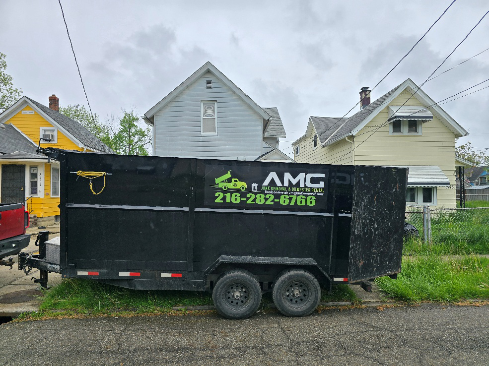 AMG Junk Removal trailer parked for hoarder house cleanup near Cleveland.
