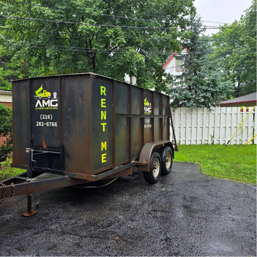 AMG roll-off dumpster positioned near a residential property for green hauling services in Cleveland.