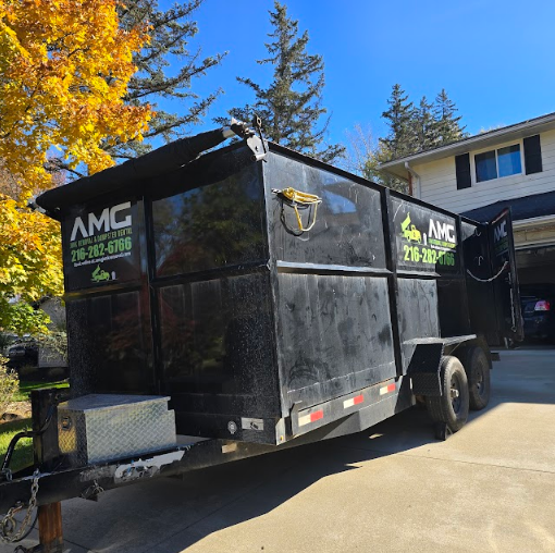 AMG dumpster rental parked in a Cleveland driveway ready for a garage cleanout.